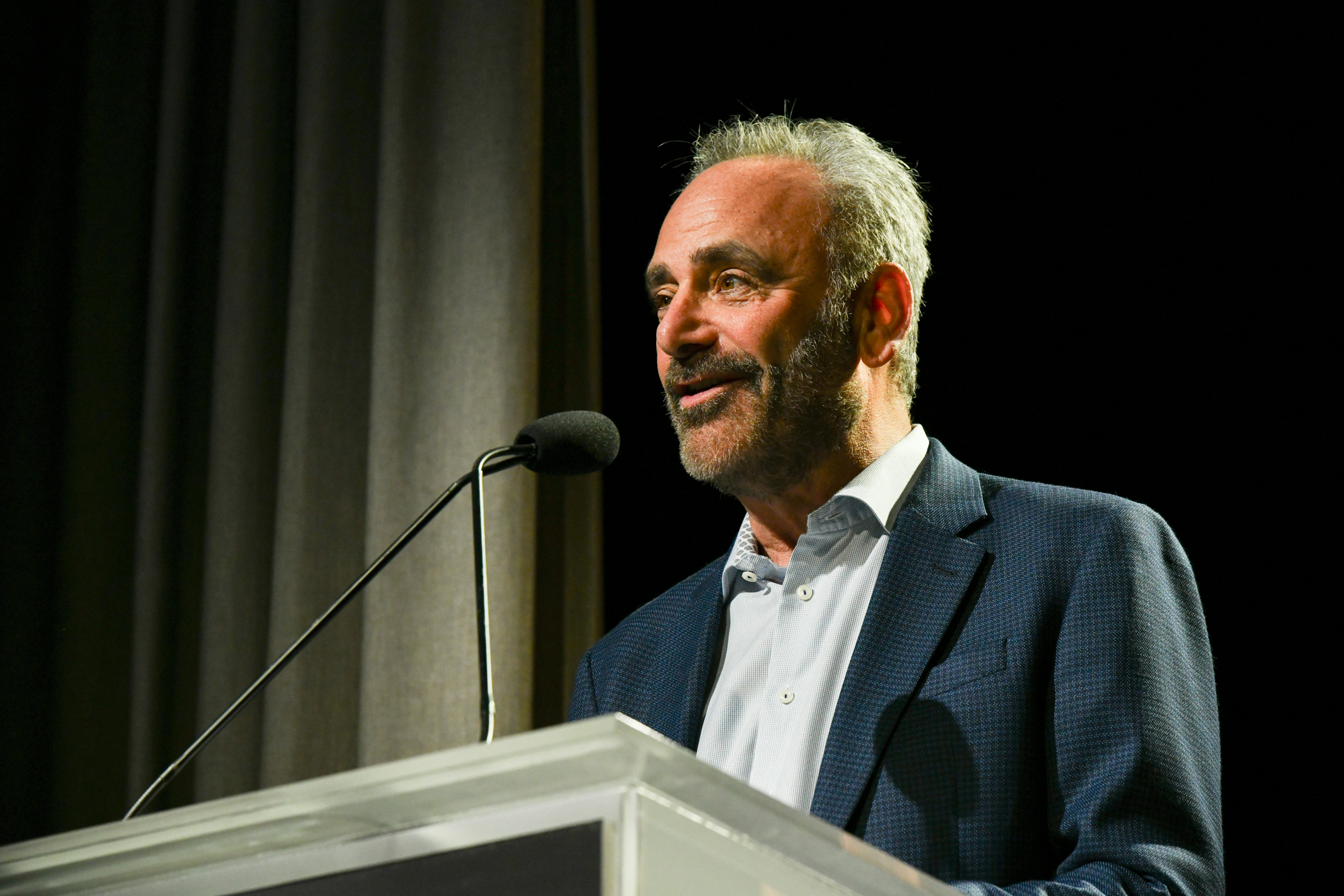 UTA executive Joe Kessler appears on a stage in front of a microphone