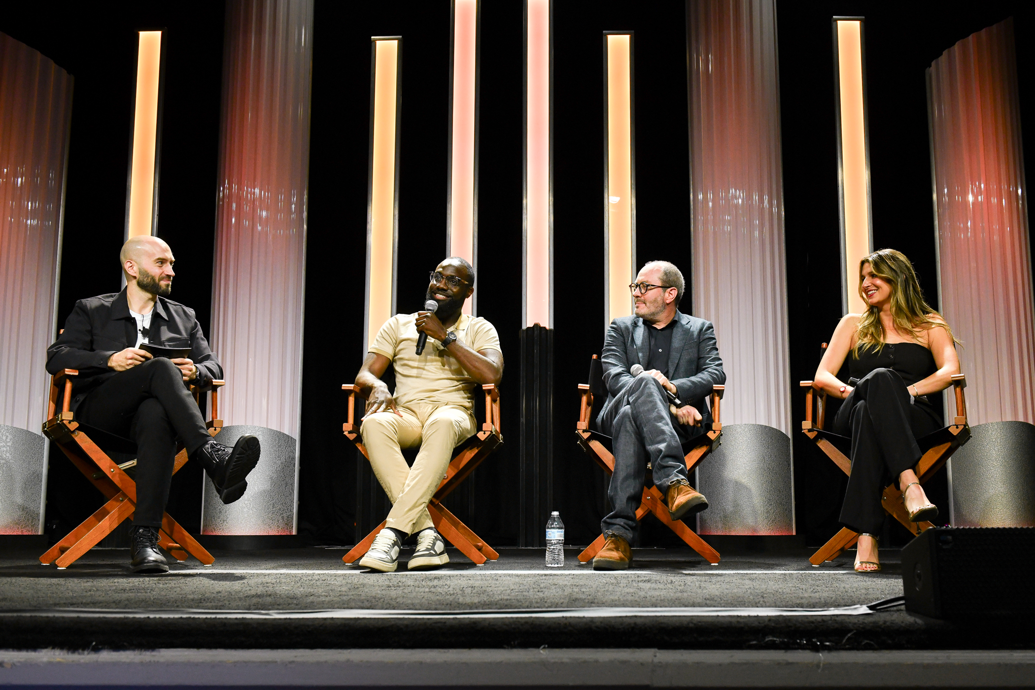 Four panelists sit on a stage at the Beverly Hilton Hotel