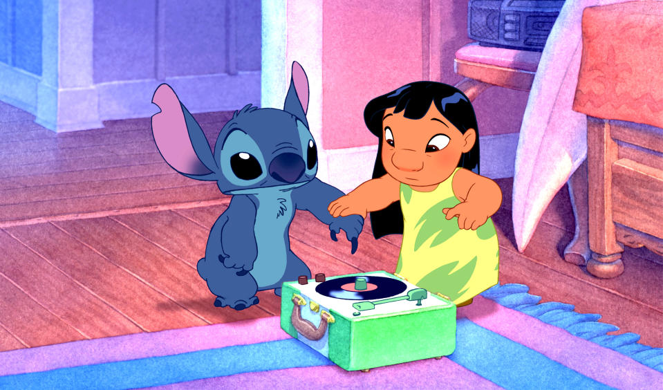 Stitch and Lilo from "Lilo & Stitch" sit on the floor listening to a record player. Lilo wears a sleeveless dress, and Stitch looks curiously at the record player