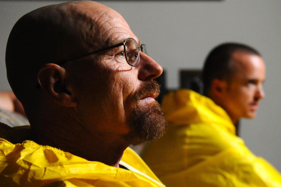 Walter White and Jesse Pinkman from Breaking Bad both in yellow hazmat suits, focused during a scene