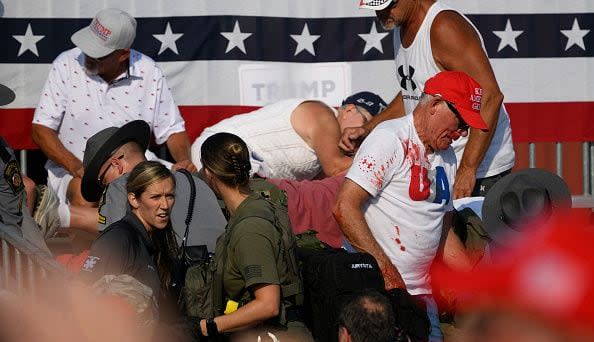 BUTLER, PENNSYLVANIA - JULY 13: Attendees scatter after gunfire rang out during a campaign rally for Republican presidential candidate, former U.S. President Donald Trump at Butler Farm Show Inc. on July 13, 2024 in Butler, Pennsylvania. Trump slumped before being whisked away by Secret Service with injuries visible to the side of his head. Butler County district attorney Richard Goldinger said the shooter and one audience member are dead and another was injured. (Photo by Jeff Swensen/Getty Images)