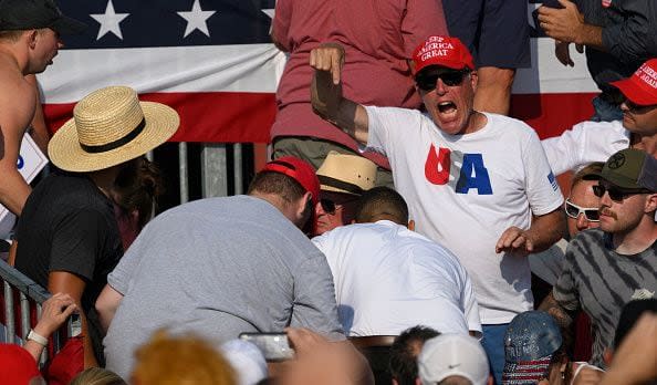 BUTLER, PENNSYLVANIA - JULY 13: Attendees scatter after gunfire rang out during a campaign rally for Republican presidential candidate, former U.S. President Donald Trump at Butler Farm Show Inc. on July 13, 2024 in Butler, Pennsylvania. Trump slumped before being whisked away by Secret Service with injuries visible to the side of his head. Butler County district attorney Richard Goldinger said the shooter and one audience member are dead and another was injured. (Photo by Jeff Swensen/Getty Images)